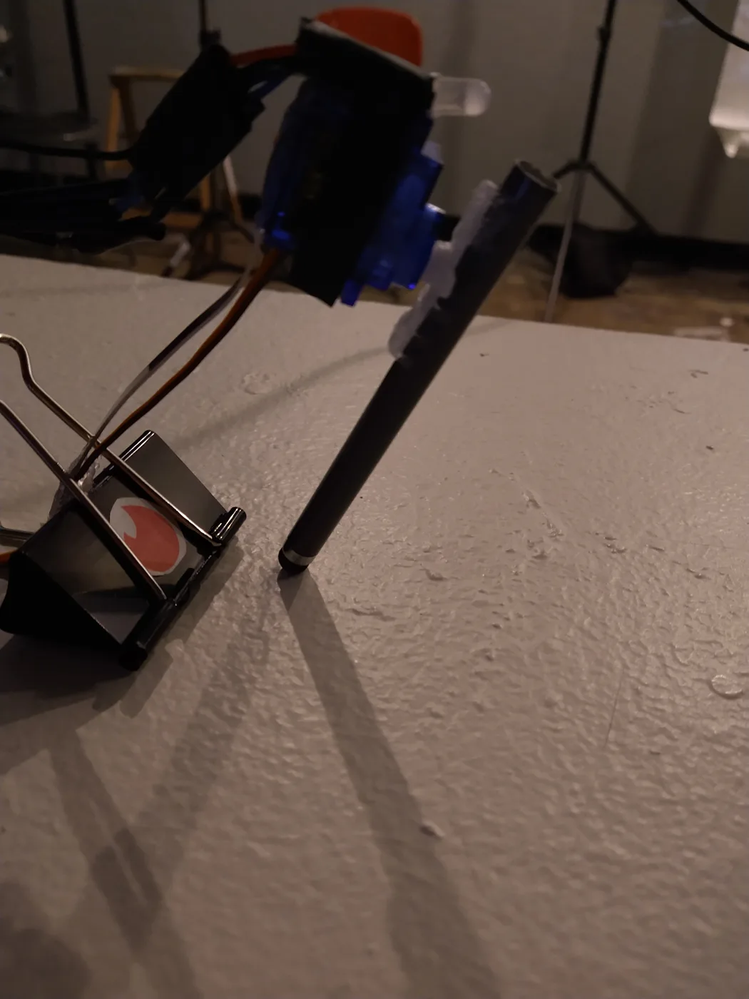 A servo-motor rig holding a stylus against a screen