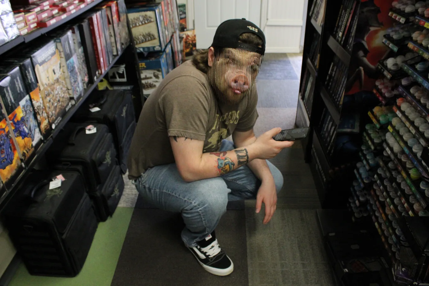 A person squatting in a game store aisle, their human and pig faces merged through thin horizontal lines