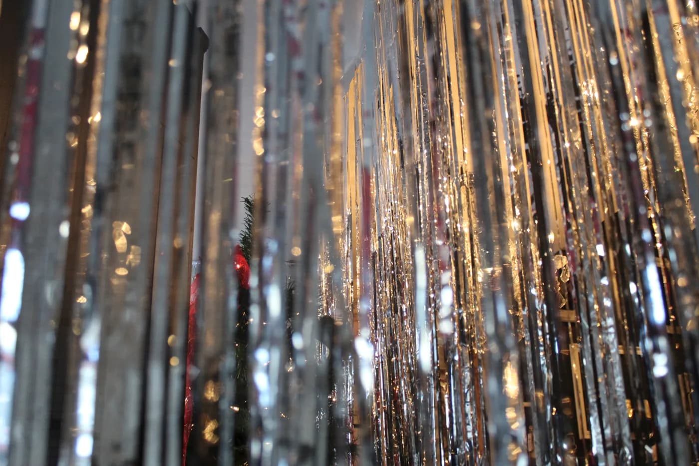 Metallic silver streamers reflecting warm store light on one side and soft natural light on the other