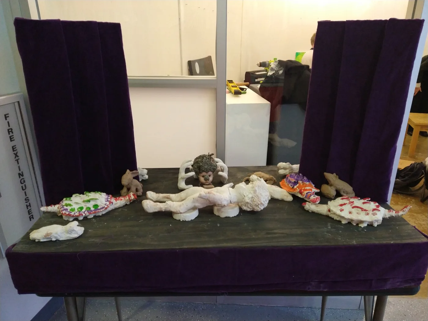 Figures displayed together on a purple velvet stage at the exhibition
