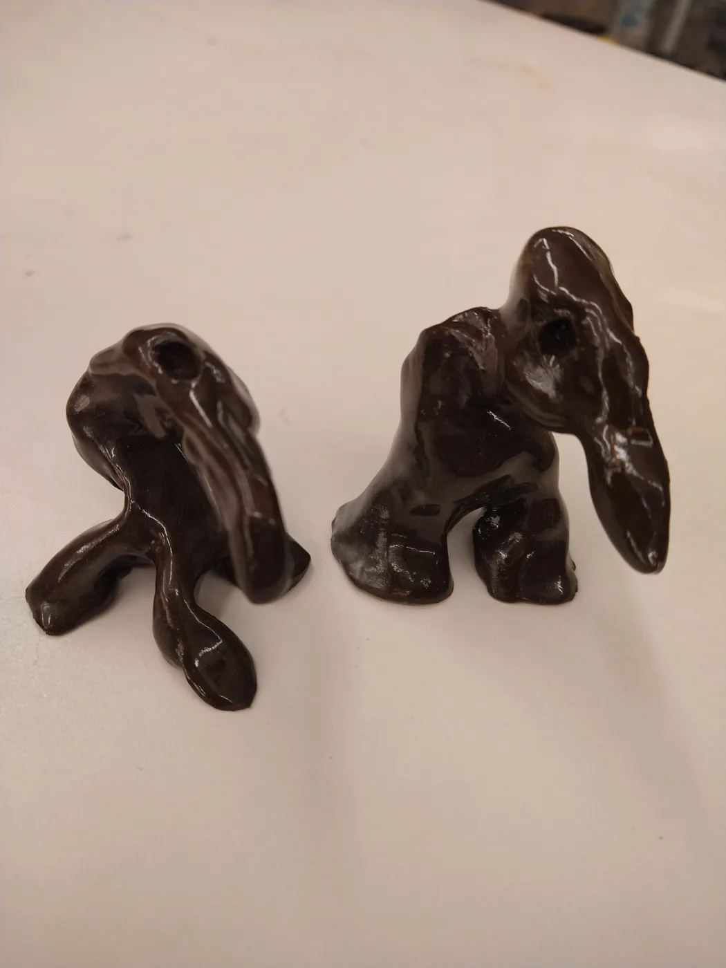 Two small glazed creatures on a white background
